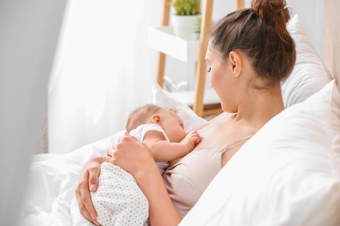 une maman allaite à la maison pendant les premiers jours avec son bébé
