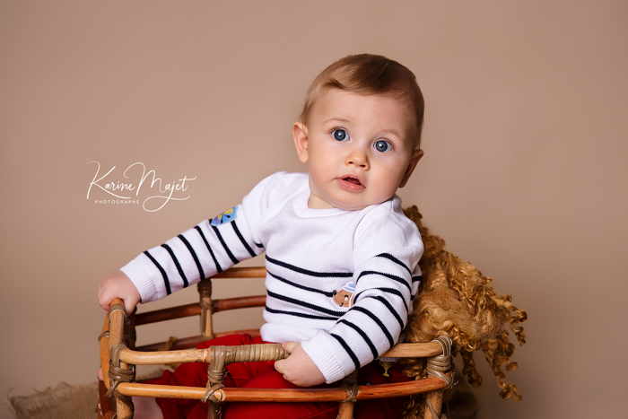 photographe bébé versailles garçon de six mois dans un panier en banbou avec un pull marinière karine majet photographe