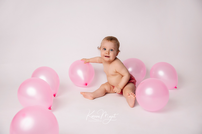 shooting photo bébé Rambouillet petite fille joue avec des ballons roses karine majet