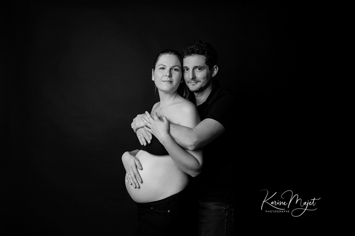 photo de grossesse en couple de profil sur fond noir Karine Majet photographe