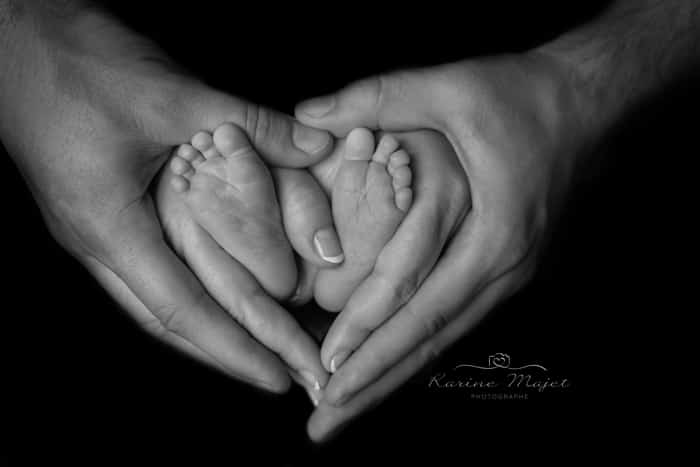 petits pieds de bébé qui forment un cœur avec les mains des parents Karine Majet