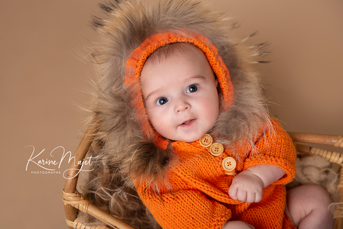séance photo bébé clamart adorable portrait d'un garçon en tenue orange tricotée Karine Majet