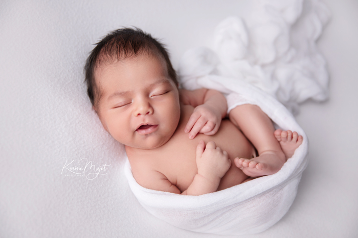 petit bébé endormi dans un cocon blanc en tissus