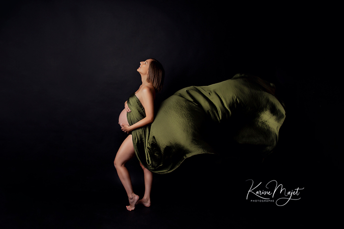 séance photo de grossesse sur fond noir maman et un voile vert olive karine majet