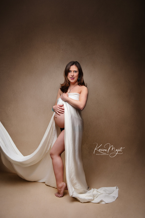 shooting à 7 mois de grossesse maman avec un voile blanc laissant apparaître son ventre karine majet