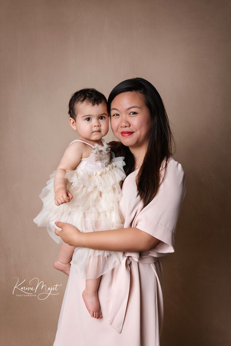 portrait romantique d'une maman avec sa fille, toutes les deux habillées avec des tenues romantiques rose et beige