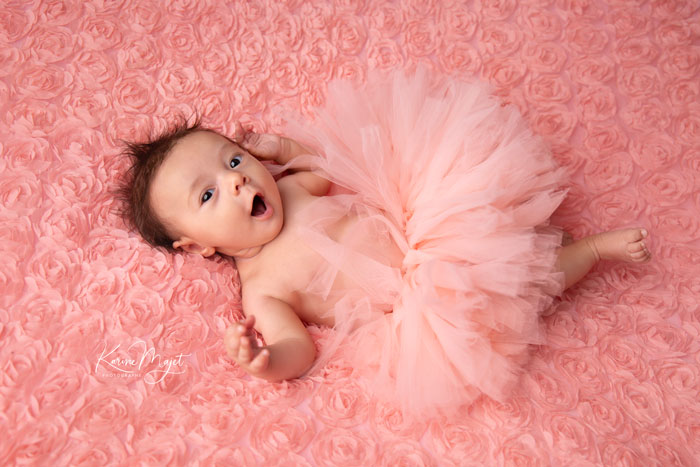 adorable petite fille habillée d'un tutu rose saumon et baillant