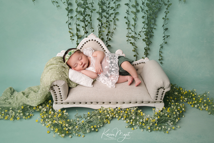photo de naissance avec une petite fille allongée sur un mini canapé Karine Majet