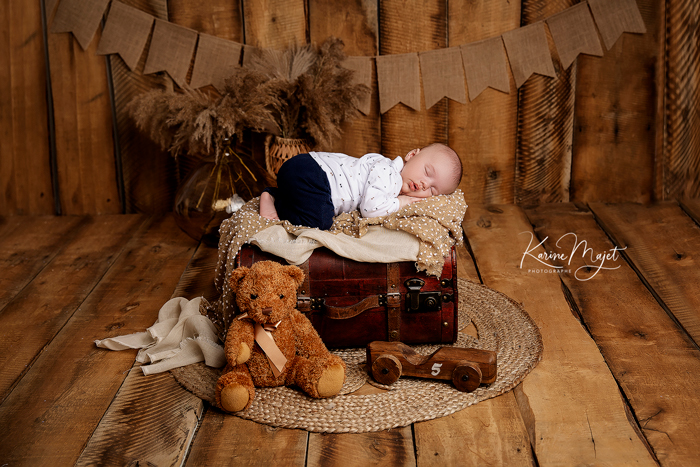 photographe naissance issy-les-moulineaux petit garçon sur une valise avec un ourson Karine Majet