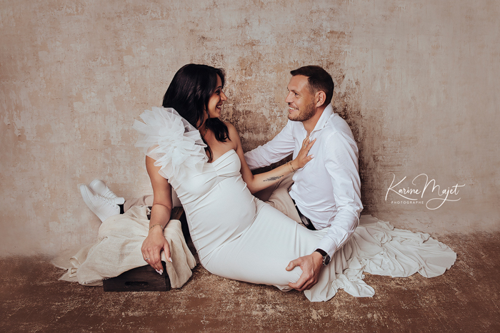 couple heureux de faire un shooting grossesse au studio de Karine Majet photographe