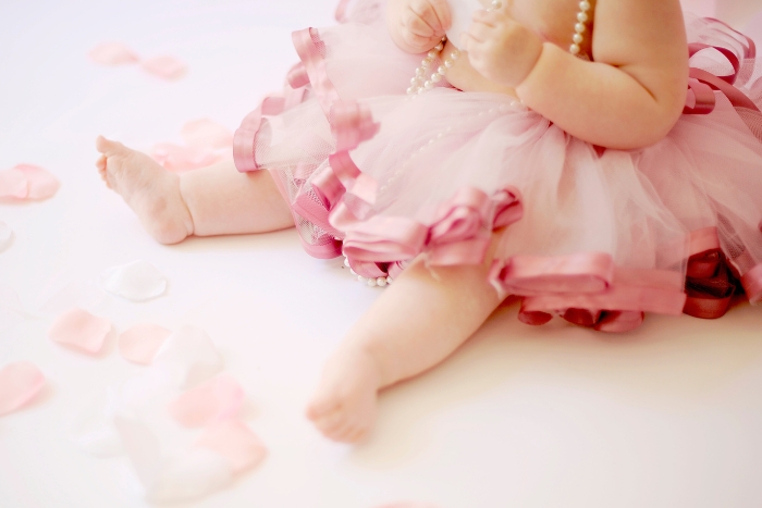 séance photo anniversaire avec les petits pieds d'une fille habillée avec un tutu rose