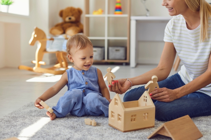 une maman montre un personnage en bois à son fils