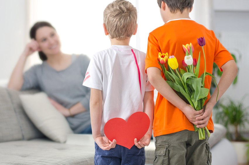 enfants offre un cœur et des fleurs à leur maman pour la fête des mères