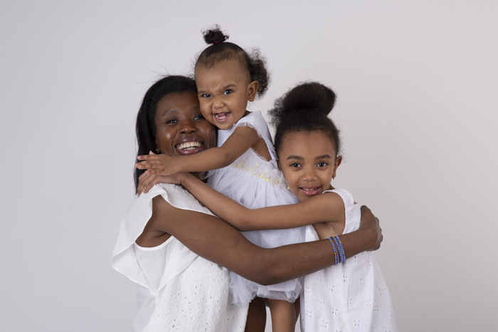 photo de famille avec une maman qui fait un gros câlin à ses deux filles Karine Majet