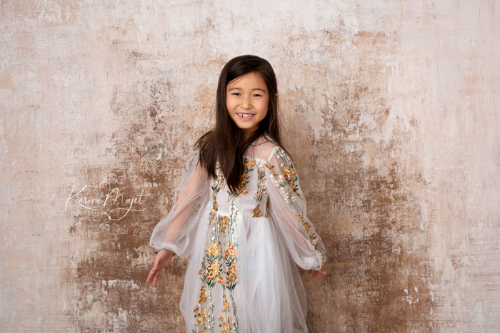 fille de six ans portant une belle robe blanche avec des fleurs brodées