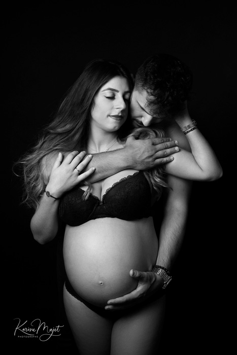 photo de couple intime sur fond noir pour un shooting grossesse en clair obscur Karine Majet