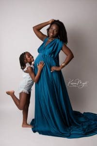 maman enceinte dans une robe bleue avec sa fille en body bleu clair