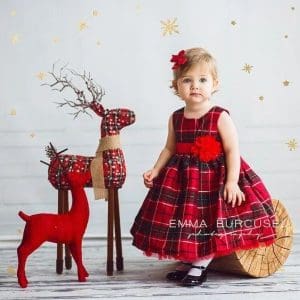 petite fille en robe écossaise rouge pour les fêtes de fin d'année