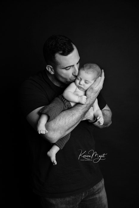 photographie pour annoncer l'arrivée de son bébé : papa avec son fils dans les bras
