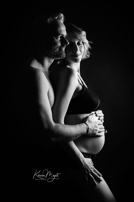 top photo en couple pour un shooting grossesse en clair obscur en studio photo