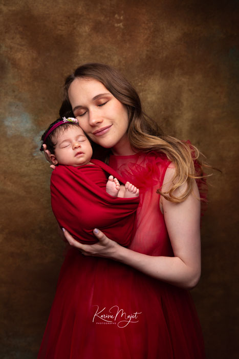 photo artistique de naissance, la maman et la petite fille portent des tenues assorties rouge grenat