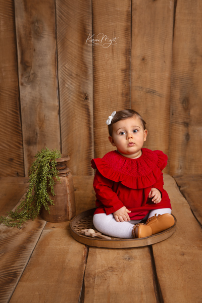 petite fille avec une robe rouge dans un décor en bois vieilli