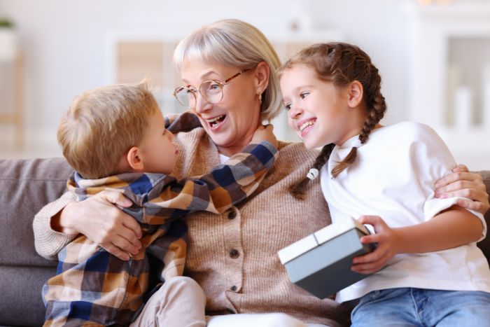 des enfants offrent un cadeau à leur grand-mère