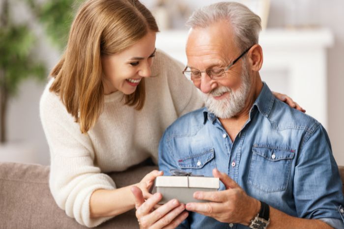 une fille offre un cadeau à son père