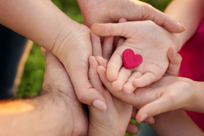 petit coeur rouge dans les mains de plusieurs personnes